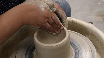 Hands using pottery wheel